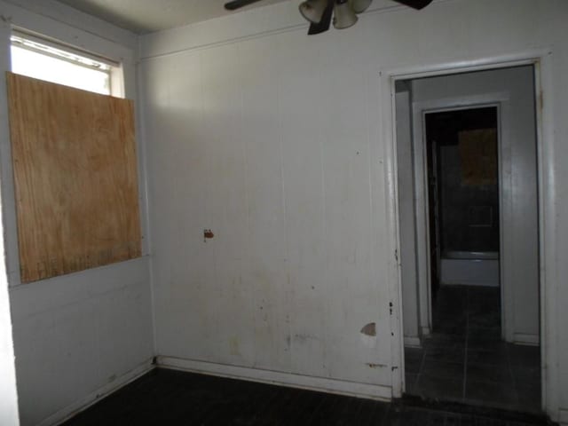 empty room with dark tile patterned flooring and ceiling fan