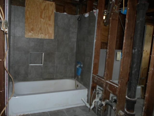 bathroom featuring tiled shower / bath combo and tile patterned flooring