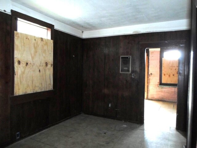 unfurnished room featuring wood walls