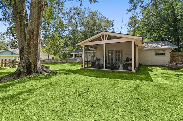 back of property featuring a sunroom and a lawn