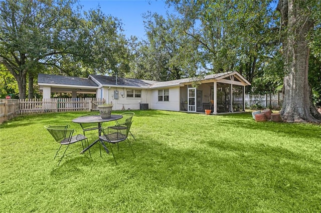 back of property with a sunroom and a yard