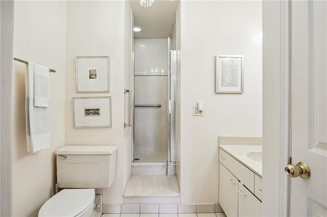 bathroom with tile patterned floors, a shower with door, vanity, and toilet