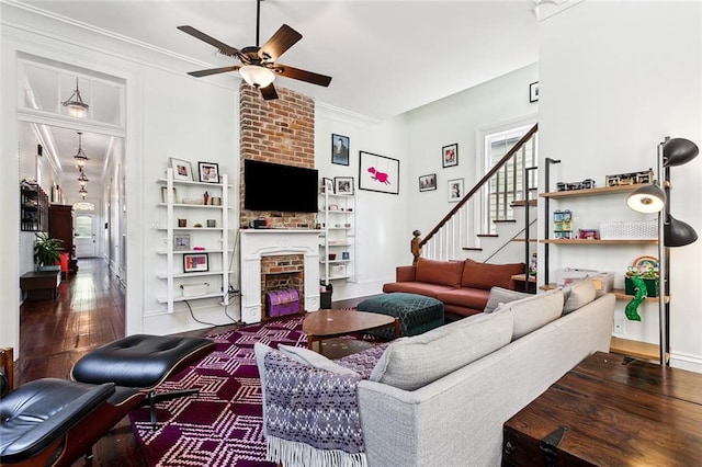 living room with ornamental molding, ceiling fan, hardwood / wood-style flooring, and a fireplace