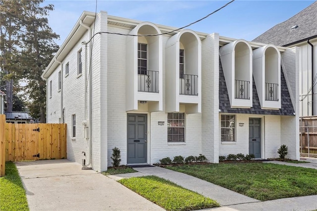 view of front facade featuring a balcony and a front lawn