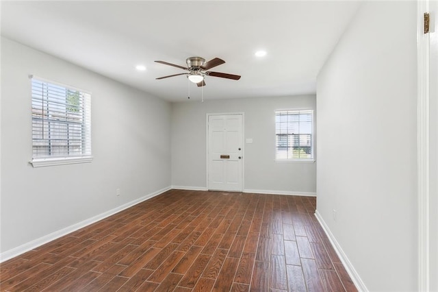 unfurnished room with dark wood-type flooring, ceiling fan, and a healthy amount of sunlight