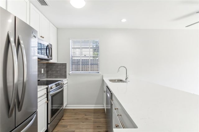 kitchen with white cabinets, backsplash, stainless steel appliances, dark hardwood / wood-style floors, and sink