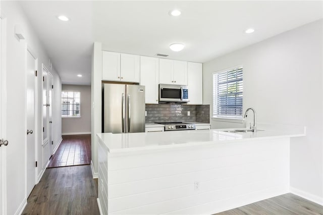 kitchen featuring stainless steel appliances, sink, white cabinetry, and a wealth of natural light