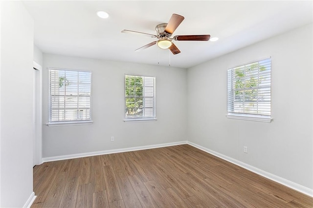 spare room with hardwood / wood-style floors, ceiling fan, and a wealth of natural light