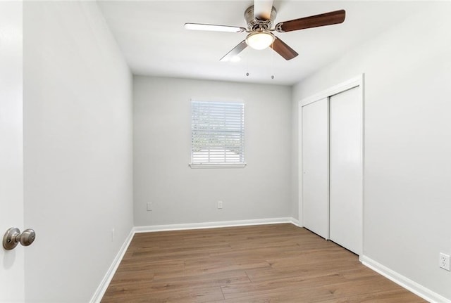 unfurnished bedroom featuring ceiling fan, light hardwood / wood-style flooring, and a closet