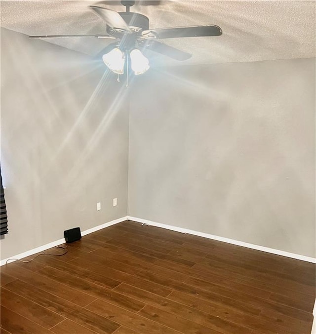 empty room with ceiling fan, a textured ceiling, and dark hardwood / wood-style flooring