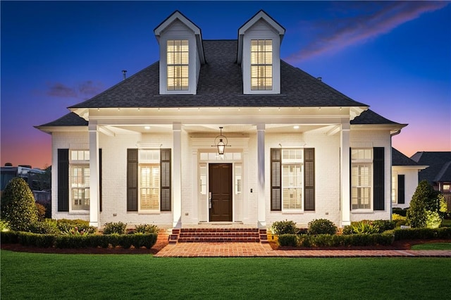 view of front of house with a lawn and a porch