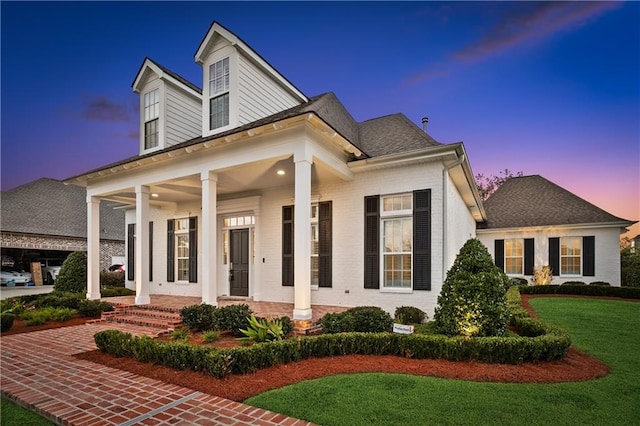 view of front of house with a yard and a porch