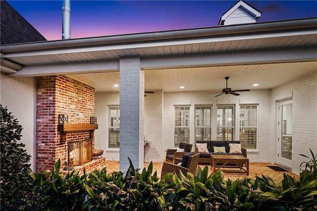 patio terrace at dusk featuring an outdoor living space and ceiling fan