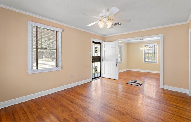 unfurnished room featuring wood-type flooring, ceiling fan with notable chandelier, and ornamental molding