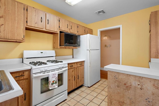 kitchen featuring light tile patterned flooring and white appliances