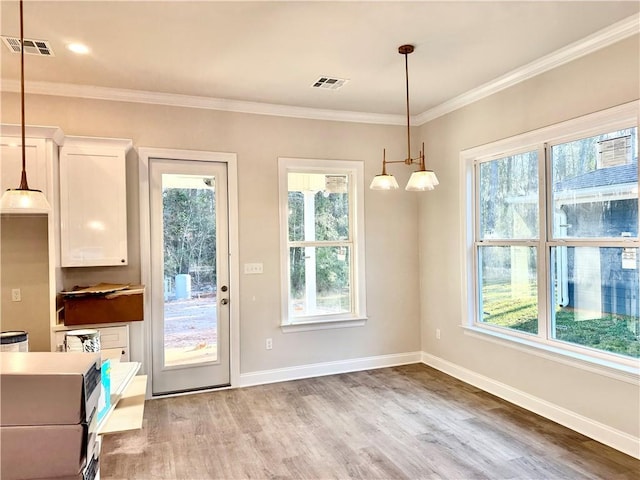 doorway to outside with visible vents, crown molding, and light wood finished floors