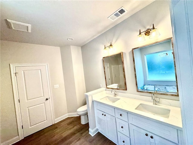 bathroom featuring wood finished floors, visible vents, and a sink