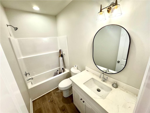 bathroom featuring vanity, bathing tub / shower combination, toilet, and wood finished floors