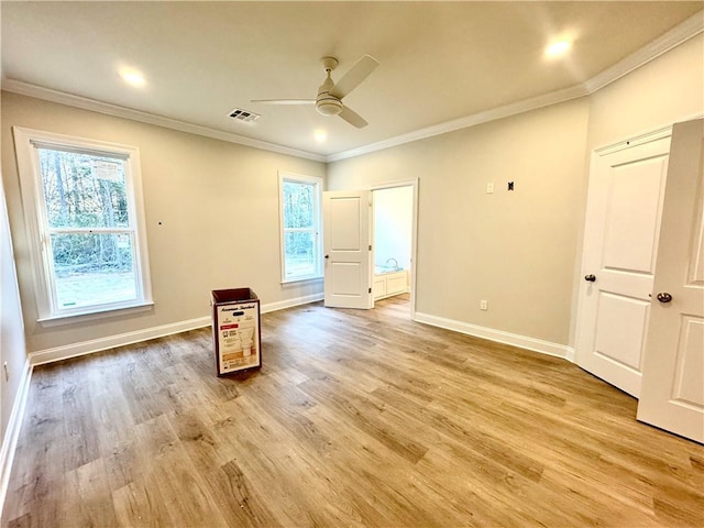 spare room featuring light wood finished floors, visible vents, crown molding, and ceiling fan