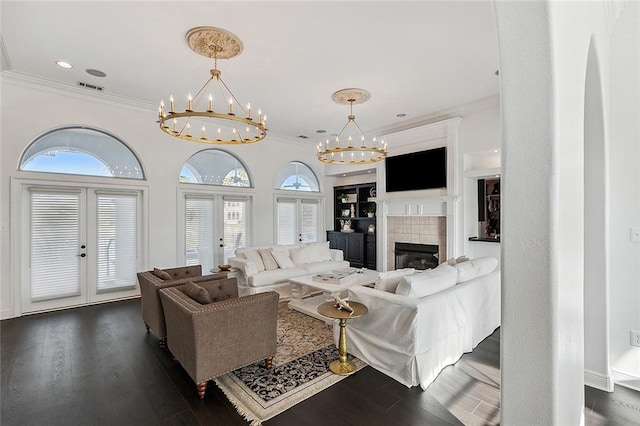 living room with crown molding, a fireplace, dark wood-type flooring, and french doors