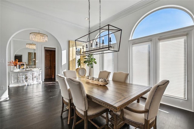 dining room featuring an inviting chandelier, ornamental molding, and dark wood-type flooring