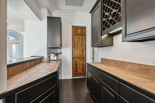 kitchen with tile countertops, dark hardwood / wood-style floors, sink, and crown molding