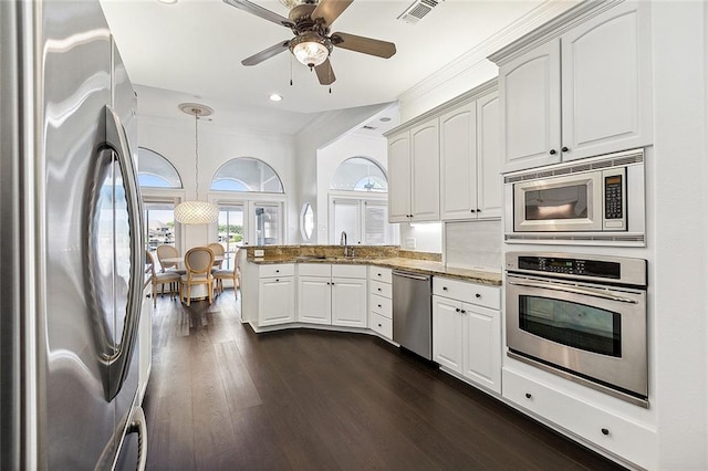 kitchen featuring appliances with stainless steel finishes, dark wood-type flooring, white cabinets, kitchen peninsula, and light stone countertops