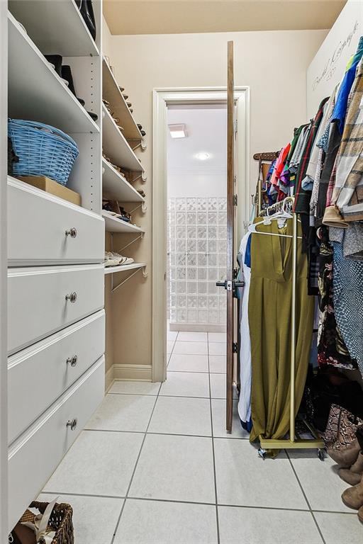 walk in closet with light tile patterned floors