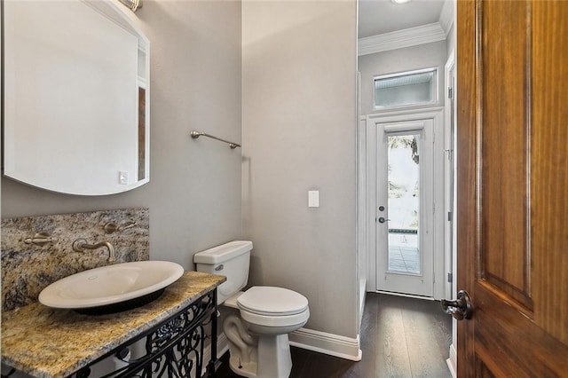 bathroom with ornamental molding, wood-type flooring, vanity, and toilet