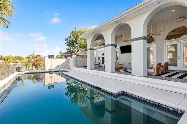 view of swimming pool featuring a patio, ceiling fan, and french doors