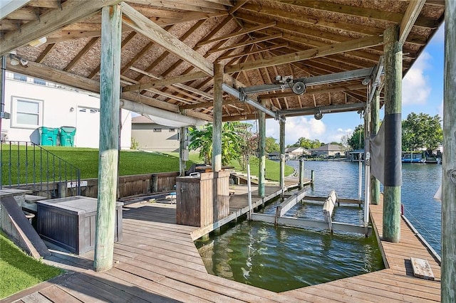 dock area with a lawn and a water view