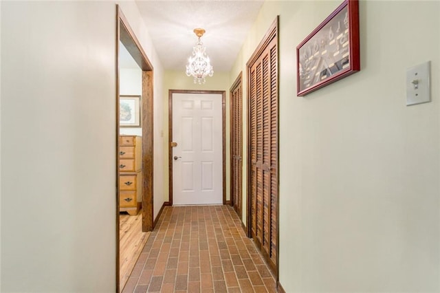 hallway with an inviting chandelier