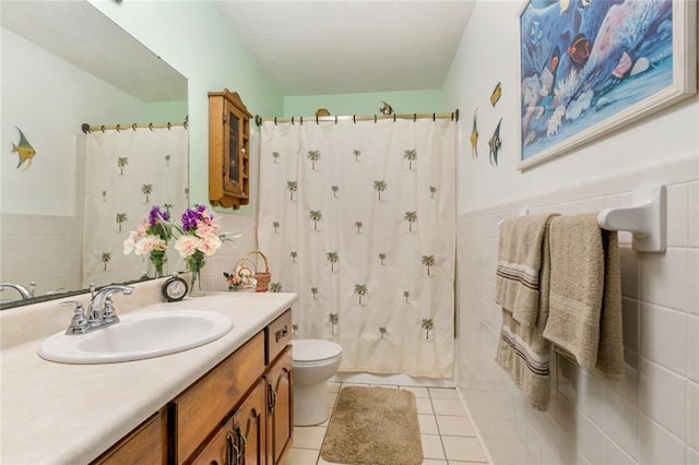 bathroom with tile walls, toilet, vanity, a shower with curtain, and tile patterned floors