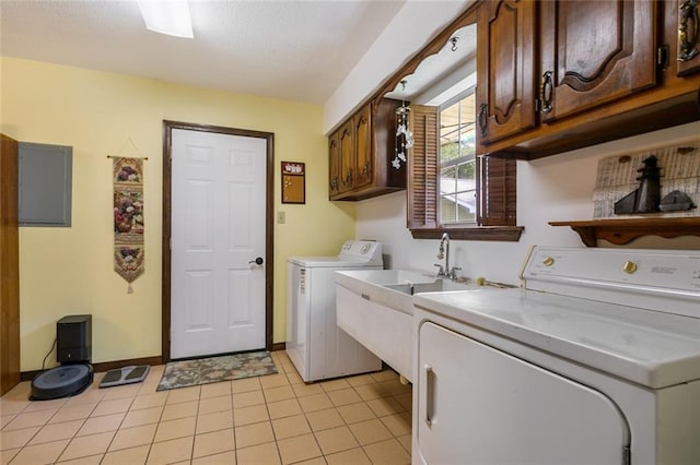 clothes washing area with light tile patterned floors, washing machine and dryer, and cabinets