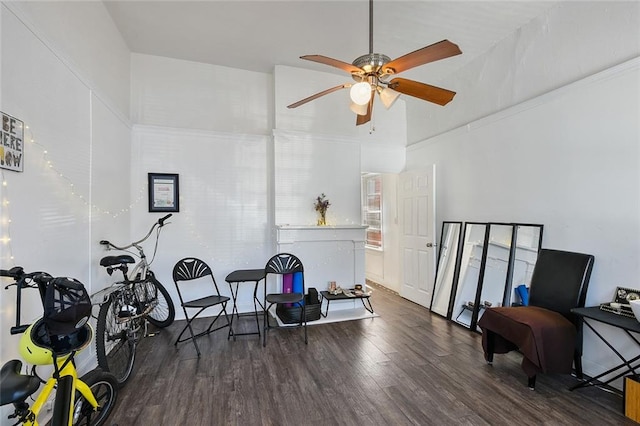 sitting room featuring ceiling fan, crown molding, and dark hardwood / wood-style flooring