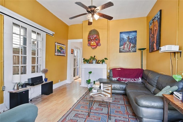 living room featuring ceiling fan and light hardwood / wood-style flooring