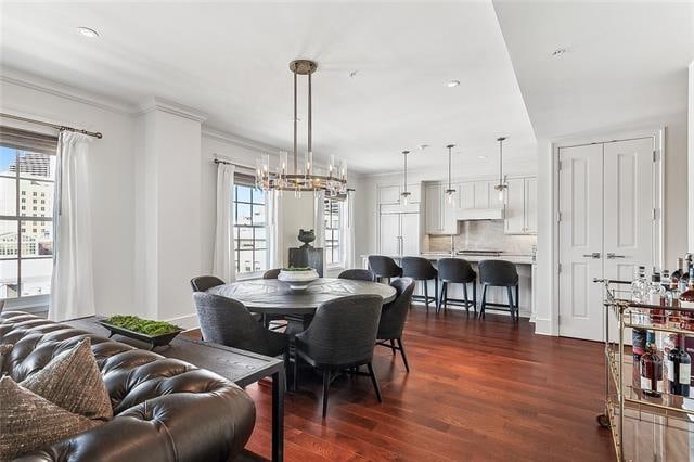 dining room featuring crown molding, dark hardwood / wood-style floors, and a notable chandelier