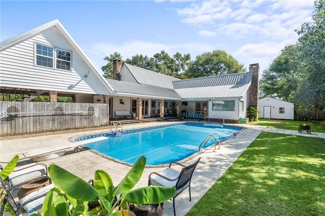 view of pool with a patio, a diving board, and a yard