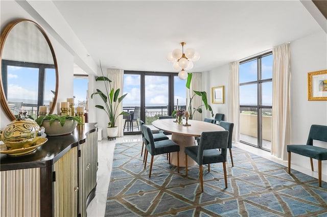 dining space featuring a wall of windows, a healthy amount of sunlight, and a notable chandelier