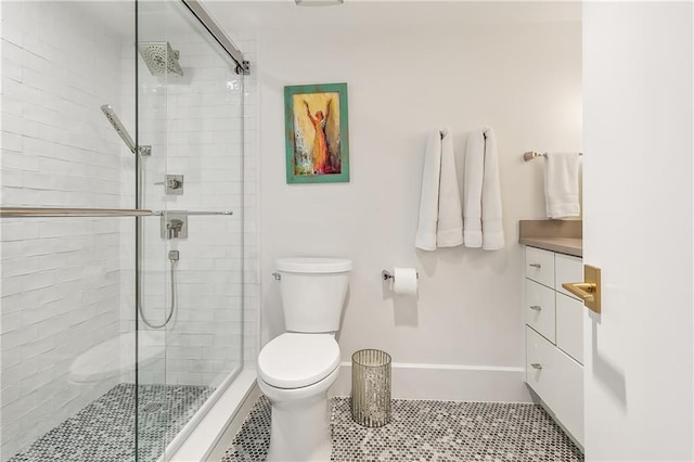 bathroom featuring vanity, tile patterned flooring, a shower with shower door, and toilet