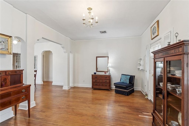 sitting room with a notable chandelier and wood-type flooring