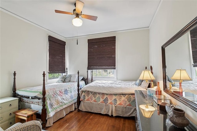 bedroom featuring crown molding, dark wood-type flooring, and ceiling fan