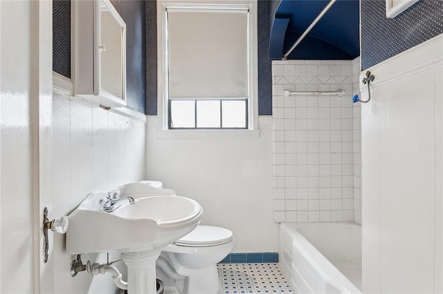 bathroom with toilet and tiled shower / bath combo