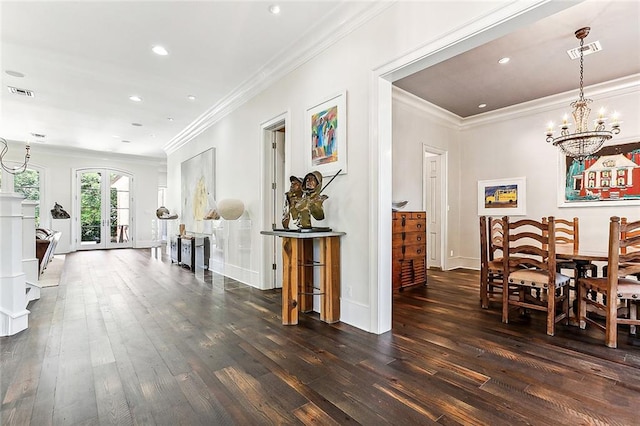 interior space with ornamental molding, dark wood-type flooring, french doors, and a notable chandelier