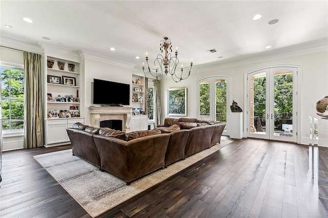 living room with an inviting chandelier, dark wood-type flooring, french doors, and built in features