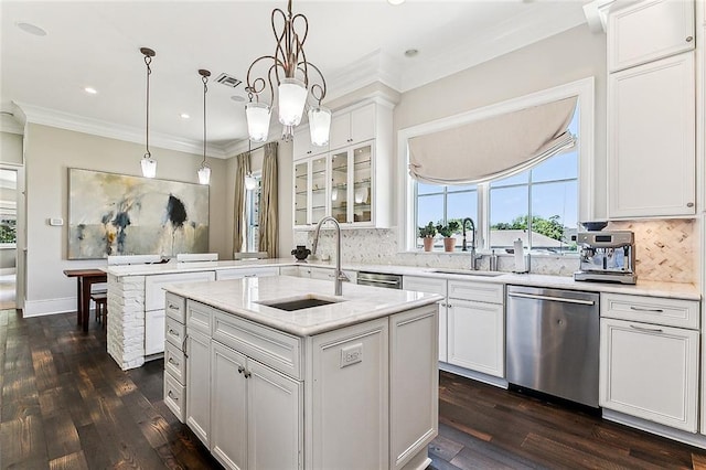 kitchen featuring dark hardwood / wood-style flooring, pendant lighting, stainless steel dishwasher, a kitchen island with sink, and sink