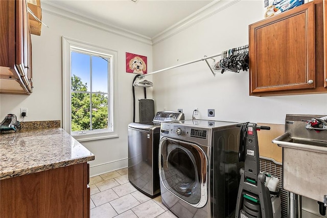 washroom featuring cabinets, light tile patterned flooring, ornamental molding, and washing machine and dryer