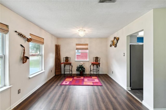 living area featuring a textured ceiling and dark hardwood / wood-style floors