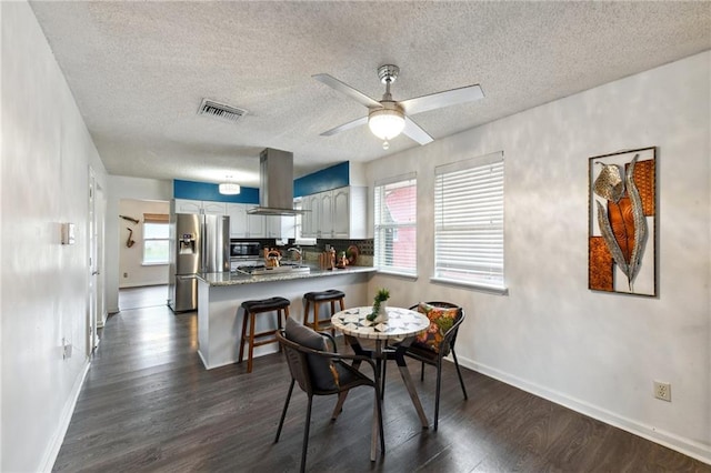 dining space featuring ceiling fan, a textured ceiling, sink, and dark hardwood / wood-style flooring