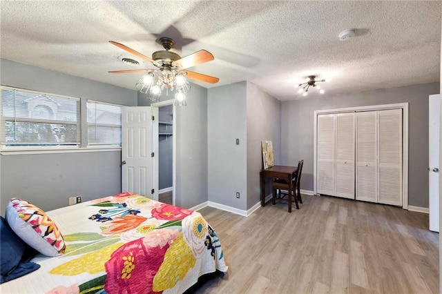 bedroom featuring a textured ceiling, ceiling fan, a closet, and light hardwood / wood-style flooring